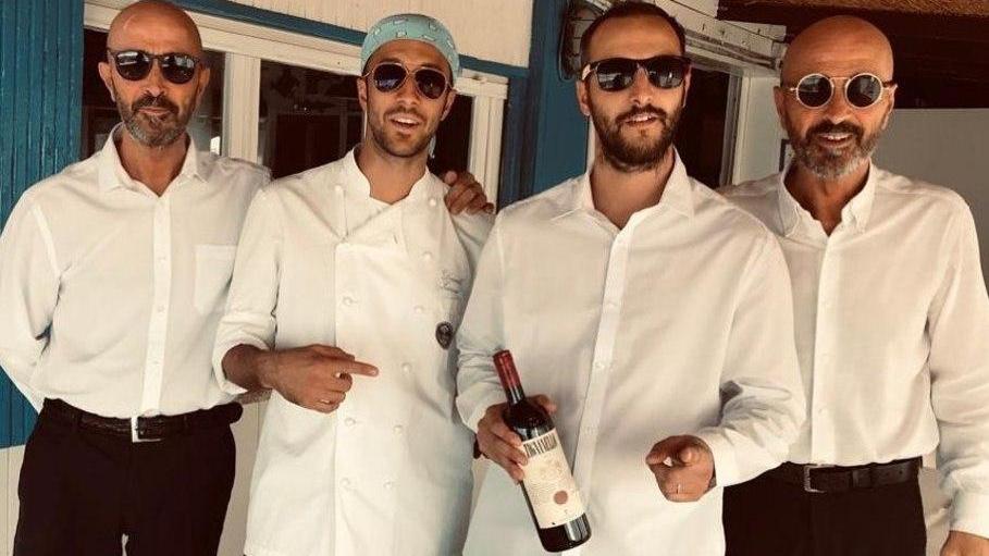 I fratelli Andrea e Daniele Zazzeri, al centro, posano insieme ai due storici camerieri del ristorante, Giovanni e Roberto Vanni