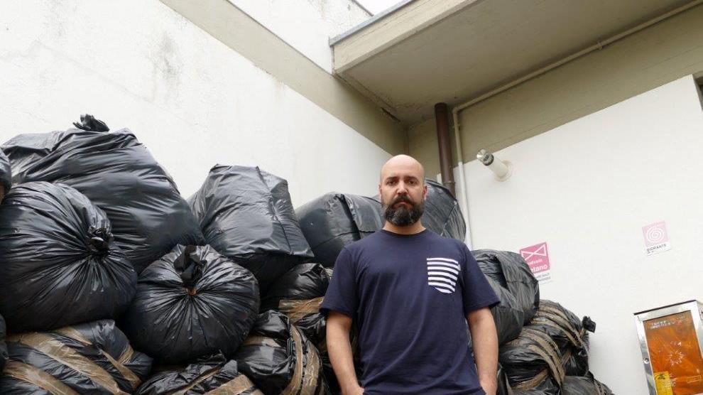 Paolo Nardi di fronte ai sacchi di scarto tessile del suo maglificio (foto Batavia)