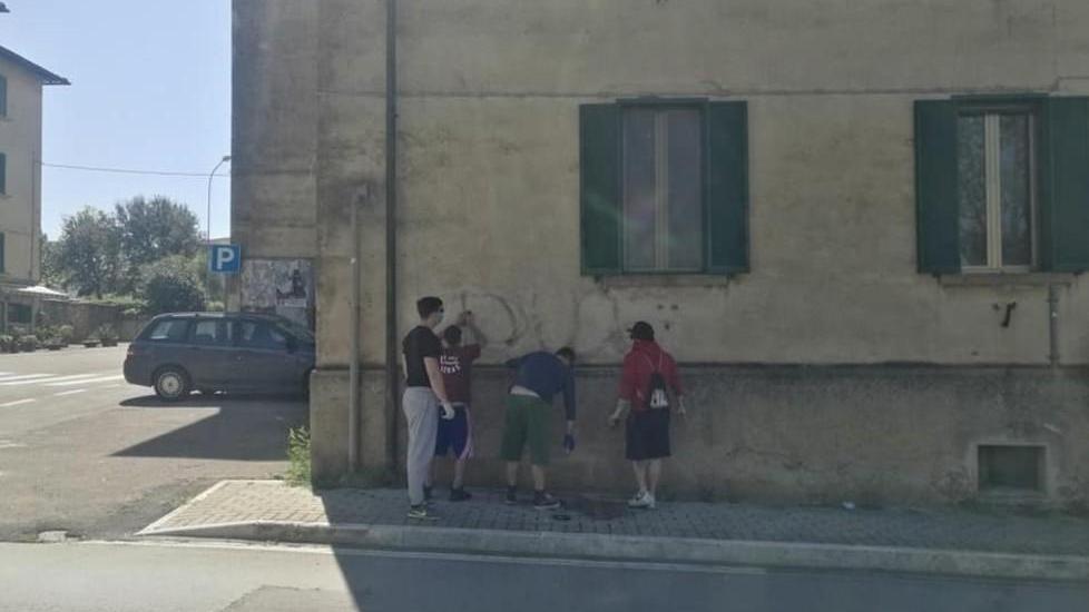 Giovani volontari cancellano dai muri le scritte fasciste