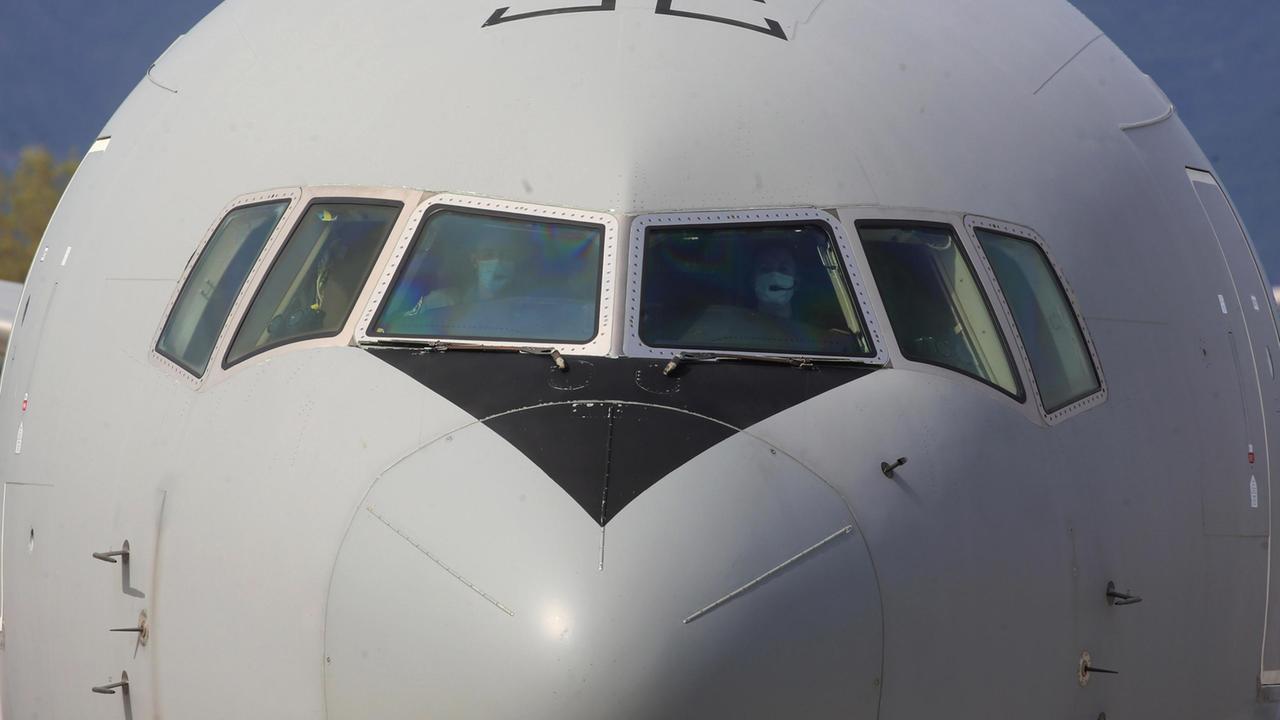 Un aereo in fase di partenza, dagli oblò si notano i componenti della cabina di pilotaggio con indosso una mascherina (foto d'archivio)