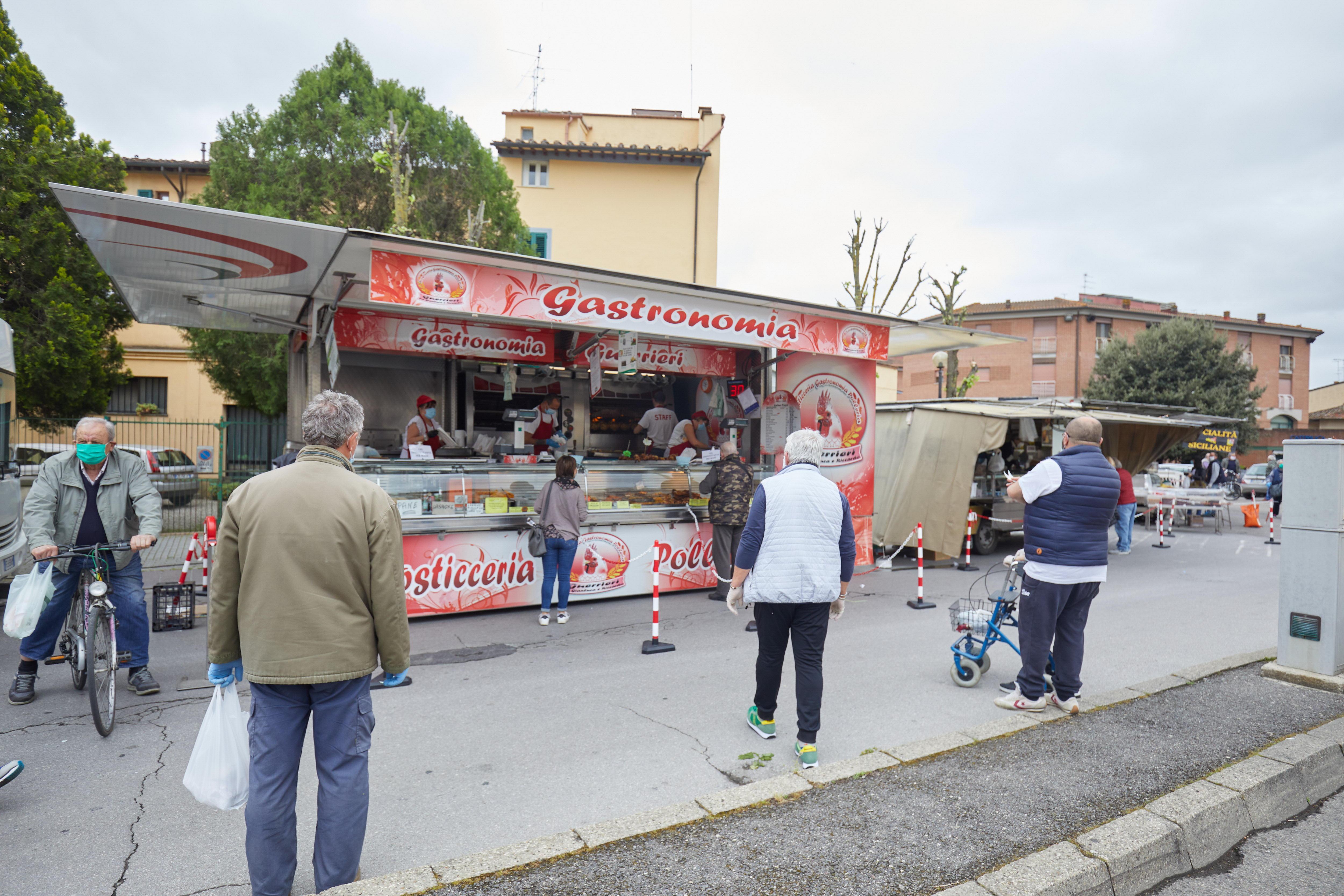 rcato di Castelfiorentino: un banco per i generi alimentari con una catena per ridurre l'affollamento e coi clienti con la distanza di sicurezza gli uni dagli altri (foto Carlo Sestini)
