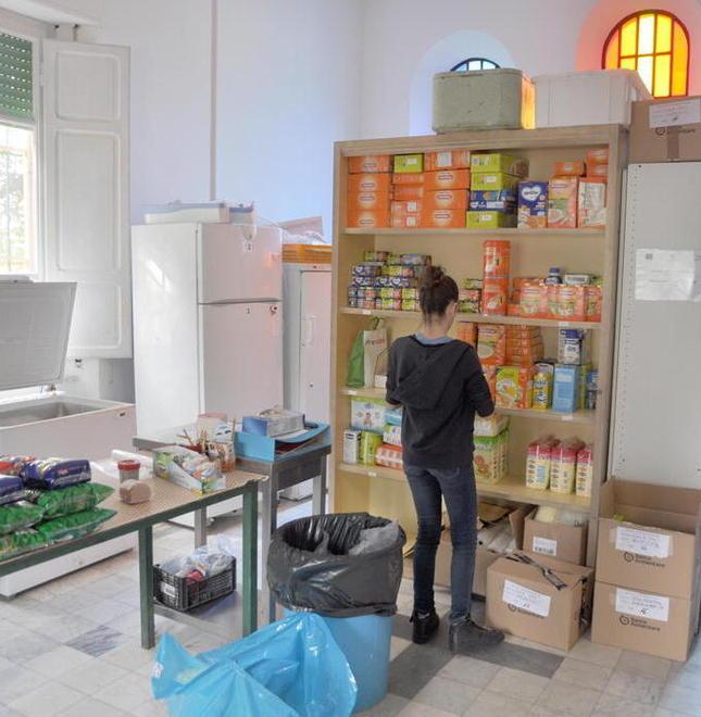 Una volontaria della Sorgente del villaggio prepara i pacchi viveri