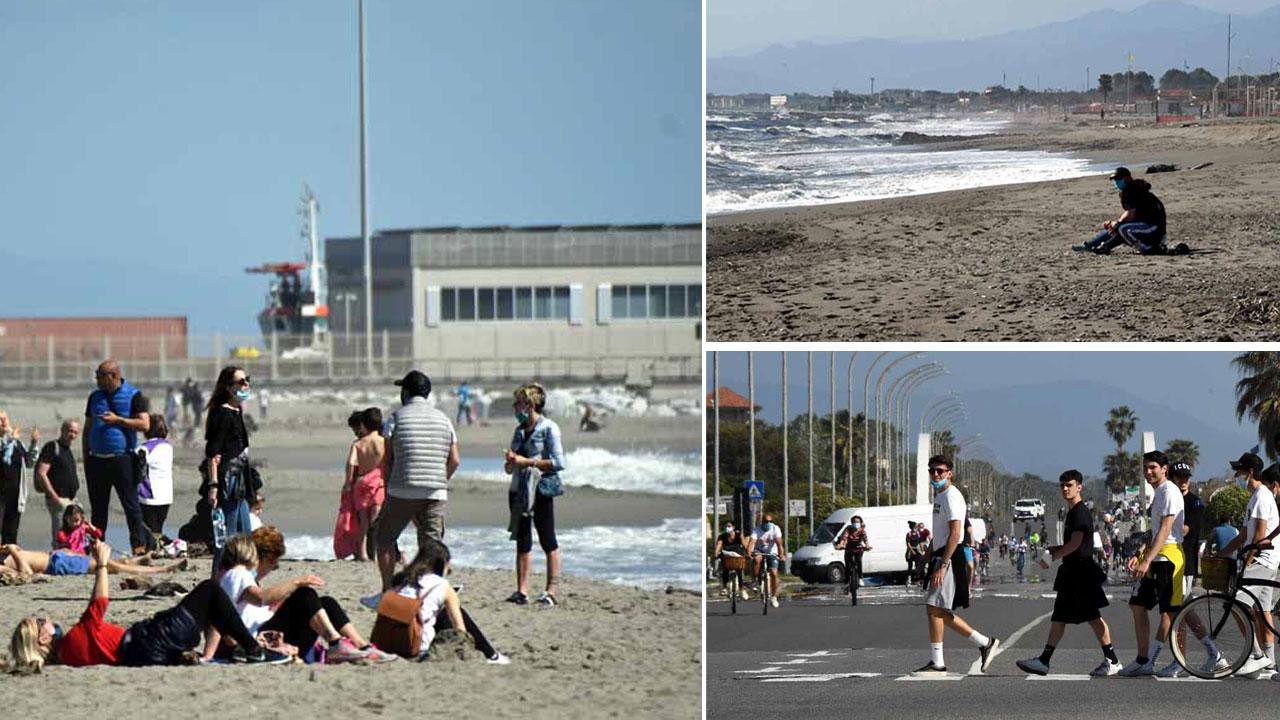 A sinistra a Marina di Carrara c’è chi si prende la tintarella, in alto la spiaggia a Poveromo, in basso ciclisti a passeggio sul lungomare di Marina di Massa