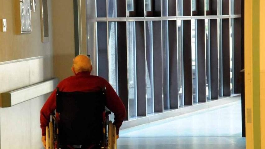 Un paziente in sedia a rotelle tra i corridoi del Noa