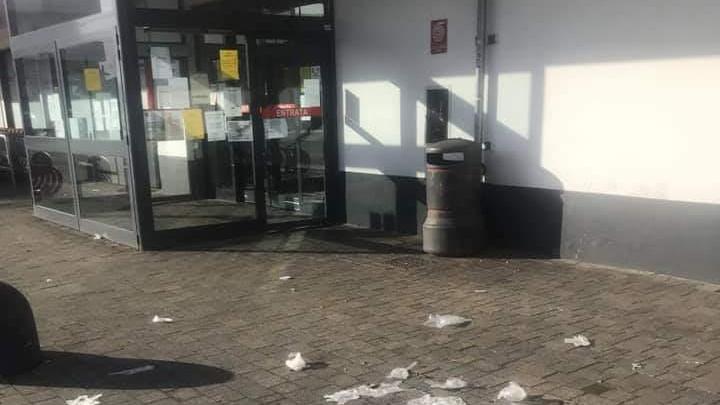 Mascherine e guanti gettati per terra all'uscita di un supermercato di Montemurlo