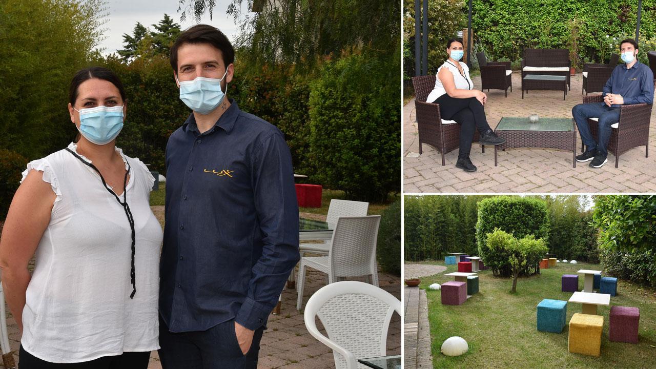 A sinistra Klaudjo Viska, titolare del Lux Lounge Drink di via Orcagna, con la compagna Sara Bellocchi nel grande spazio immerso nel verde davanti al locale
In alto, la coppia testa le distanze tra le sedute ai tavoli; in basso, uno degli angoli con i tavoli nel parco-giardino del Lux Lounge Drink (Fotoservizio Agenzia Bf)