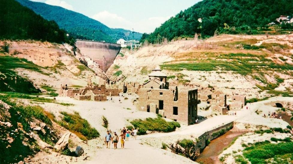 Il lago svuotato nel 1994, con il paese sommerso di Fabbriche di Careggine e, sullo sfondo, la diga Enel (Foto Matteo Bini)