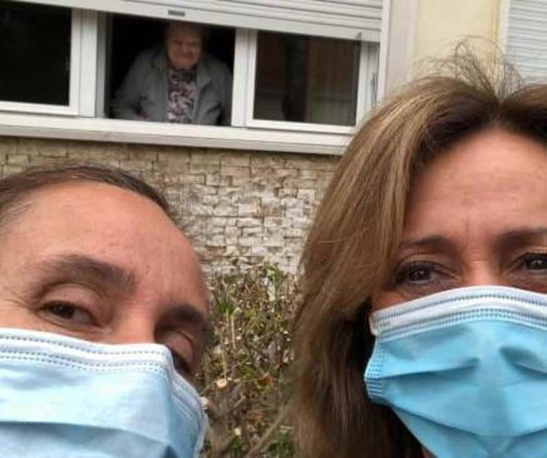 Due volontarie davanti alla casa di un'anziana