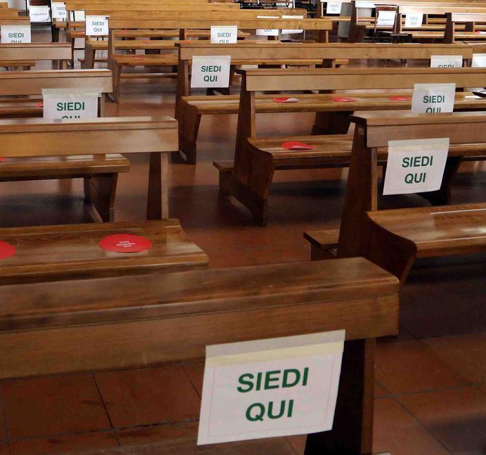 La preparazione dei banchi in chiesa per Messe in sicurezza
