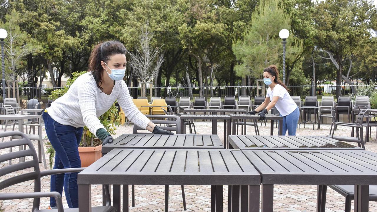 Due dipendenti dello Chalet della Rotonda sistemano i tavoli in vista della riapertura di martedì 19 maggio, seguendo le regole anti-contagio (Foto di Michele Silvestri)