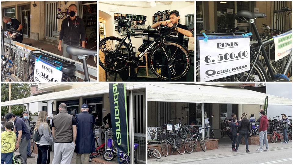 I fratelli Parra nel loro negozio, la ciclo officina de La Belle Equipe, alcune delle persone in fila fuori dai negozi di biciclette della città e il cartello che promuove il bonus valido appunto per i pisani poichè residenti in una città con più di 50.000 abitanti