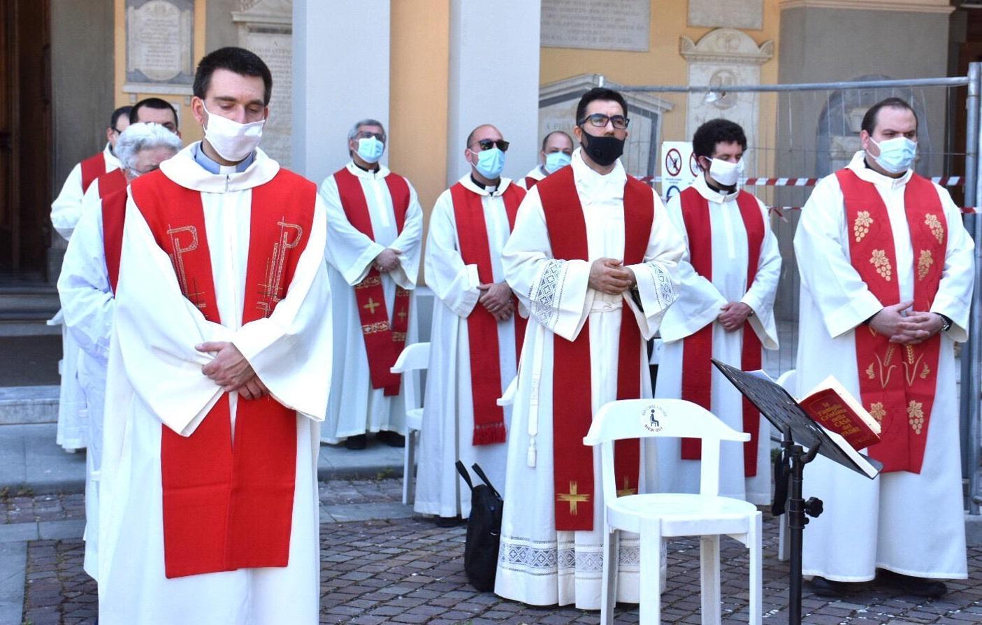 Un gruppo di sacerdoti (con la mascherina sul volto) durante la messa per la patrona santa Giulia