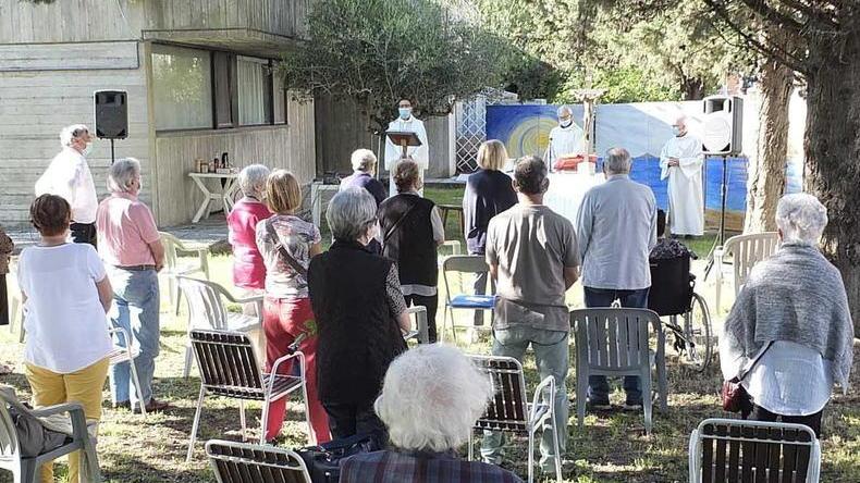 Fedeli fuori dalla chiesa, la messa è in giardino: per ogni posto una X disegnata sull’erba