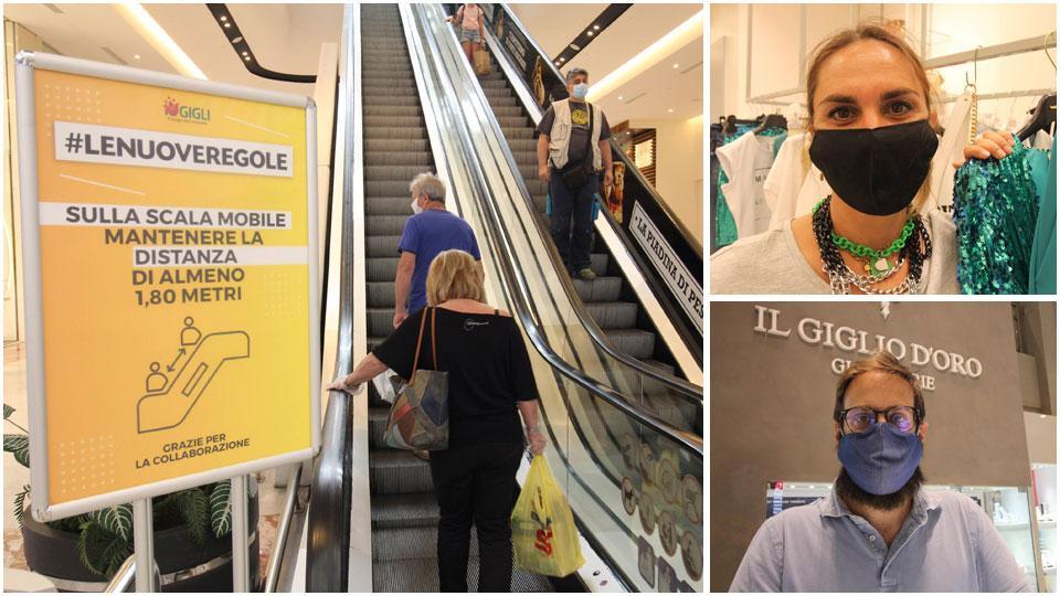 Il cartello installato all’ingresso della scala mobile all’interno del Centro commerciale I Gigli dove si raccomanda di mantenere la distanza di almeno 1,80 metri, Simona Mesisca responsabile del negozio Fabbri abbigliamento e Alessio Bocciolini dipendente” Il giglio d’oro”. I negozianti hanno commentato la ripresa dell’attività commerciale dopo il lungo periodo di lockdown
