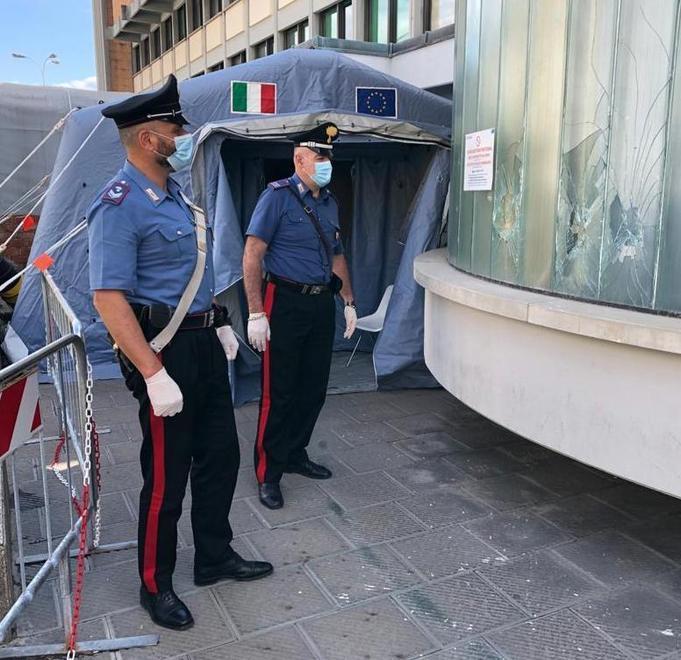 I carabinieri davanti alle vetrate infrante dell’ospedale