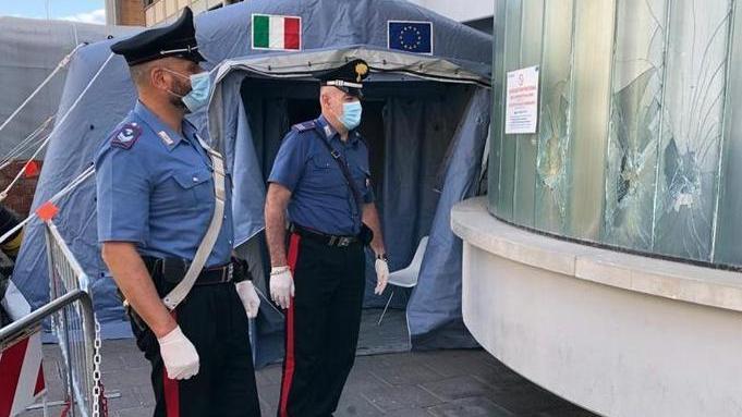 I carabinieri davanti alle vetrate infrante dell’ospedale