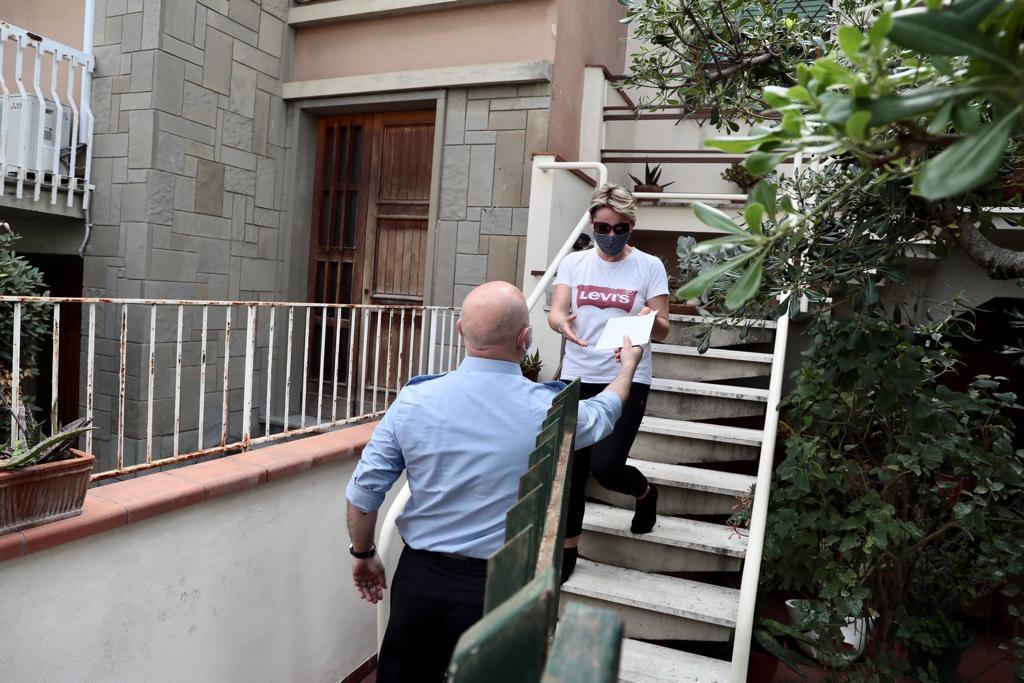 Un dipendente del Comune di Empoli consegna una copia della Costituzione ad una nuova cittadina italiana