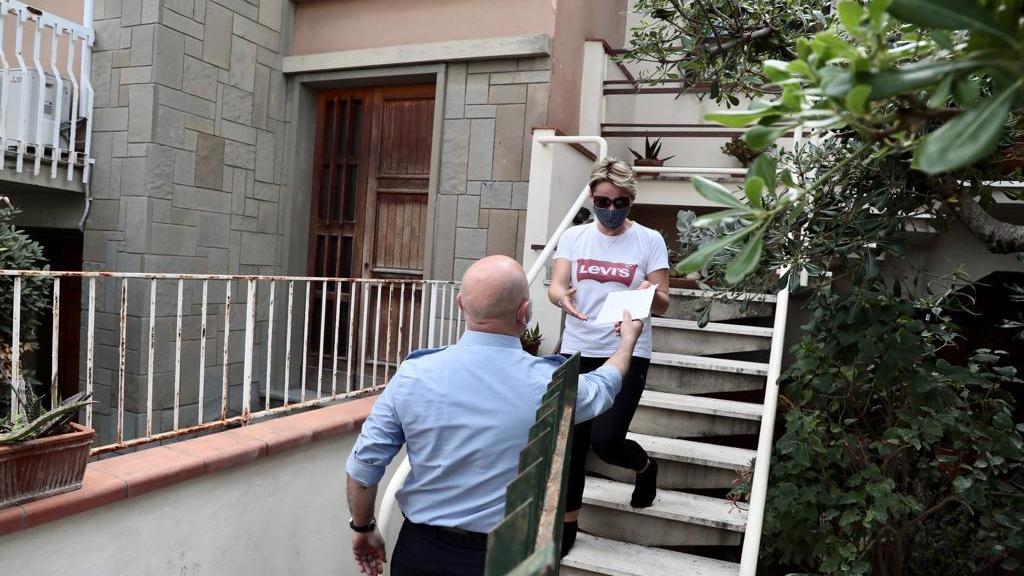 Un dipendente del Comune di Empoli consegna una copia della Costituzione ad una nuova cittadina italiana