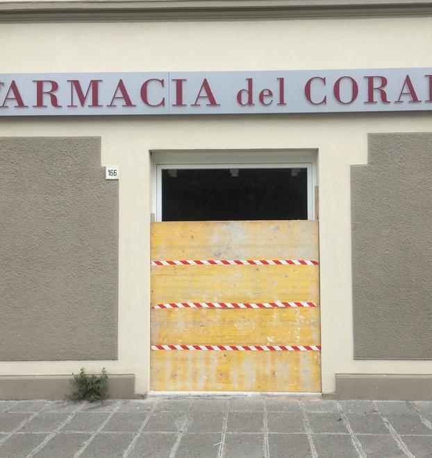 Spacca col tombino la vetrata della farmacia