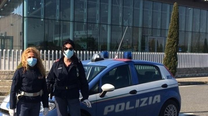 Una volante della polizia e due agenti durante un controllo