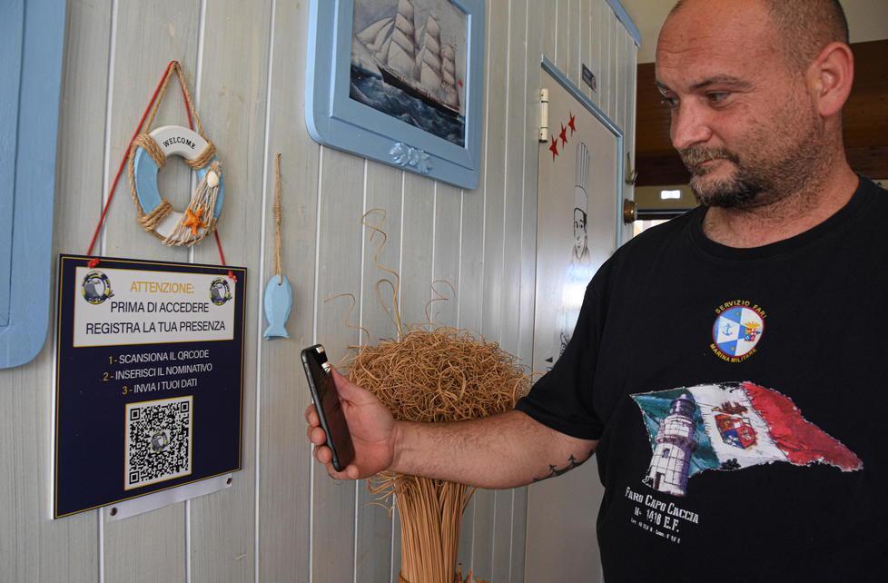 Simone Guerrini mostra come funziona la registrazione tramite QrCode all'ingresso dello stabilimento (Foto Agenzia Bf)