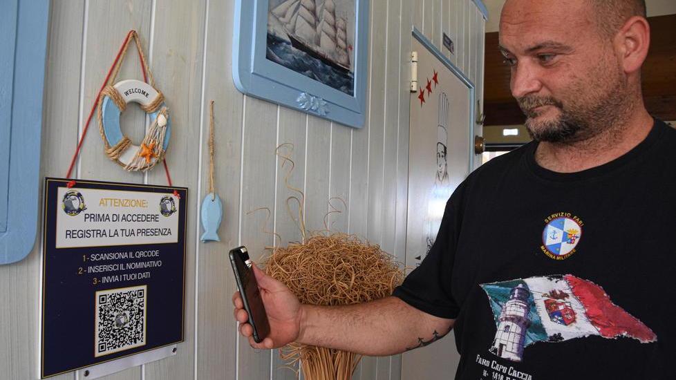 Simone Guerrini mostra come funziona la registrazione tramite QrCode all'ingresso dello stabilimento (Foto Agenzia Bf)