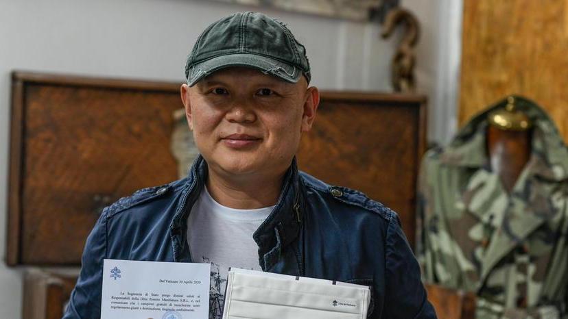 Qiaoyong Zhou mostra una mascherina inviata al Vaticano e la lettera ricevuta dalla segreteria di Stato