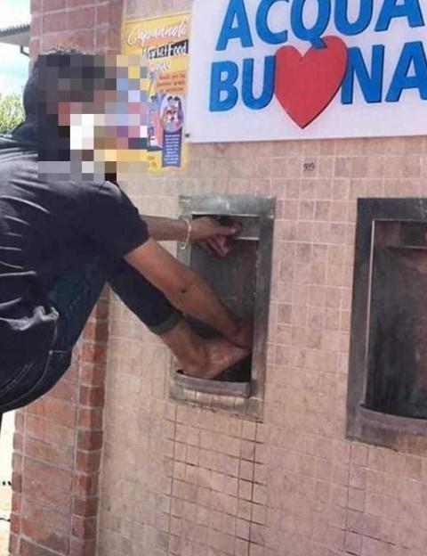 La foto postata su Facebook col giovane che si lava i piedi nel fontanello di piazza Pertini a Capannoli