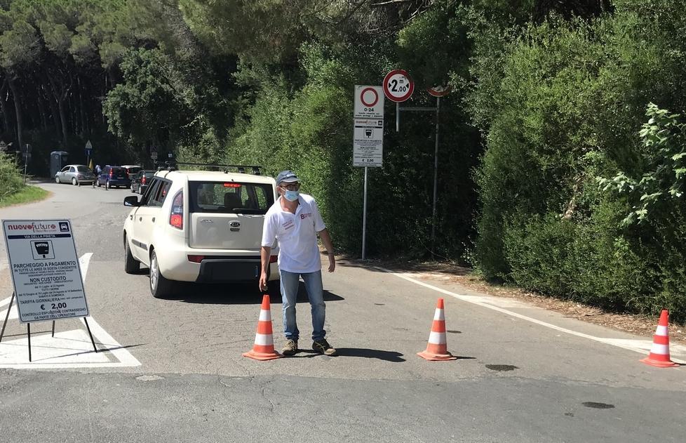 Parcheggio completo: un operatore della Nuovo Futuro sistema i birilli per chiudere l'accesso alla strada