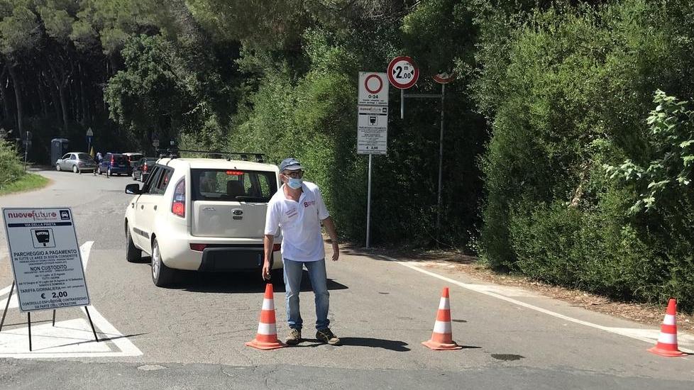 Parcheggio completo: un operatore della Nuovo Futuro sistema i birilli per chiudere l'accesso alla strada
