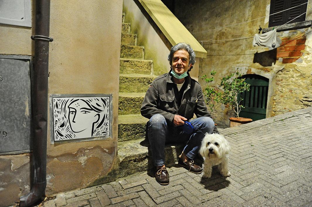 Il pittore Stefano Tonelli accanto ad uno dei suoi volti (foto Michele Falorni/Silvi)