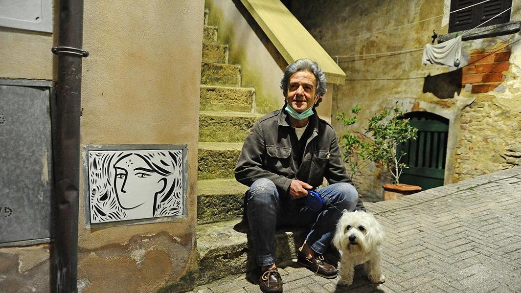 Il pittore Stefano Tonelli accanto ad uno dei suoi volti (foto Michele Falorni/Silvi)