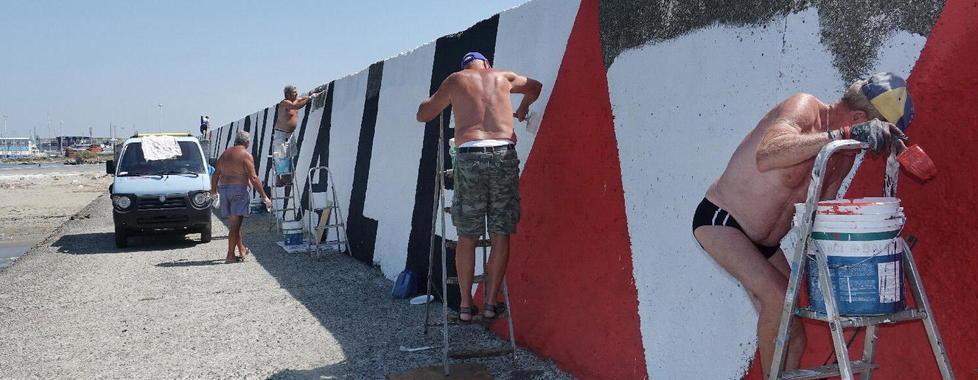Volontari ritinteggiano la scritta al Muraglione
