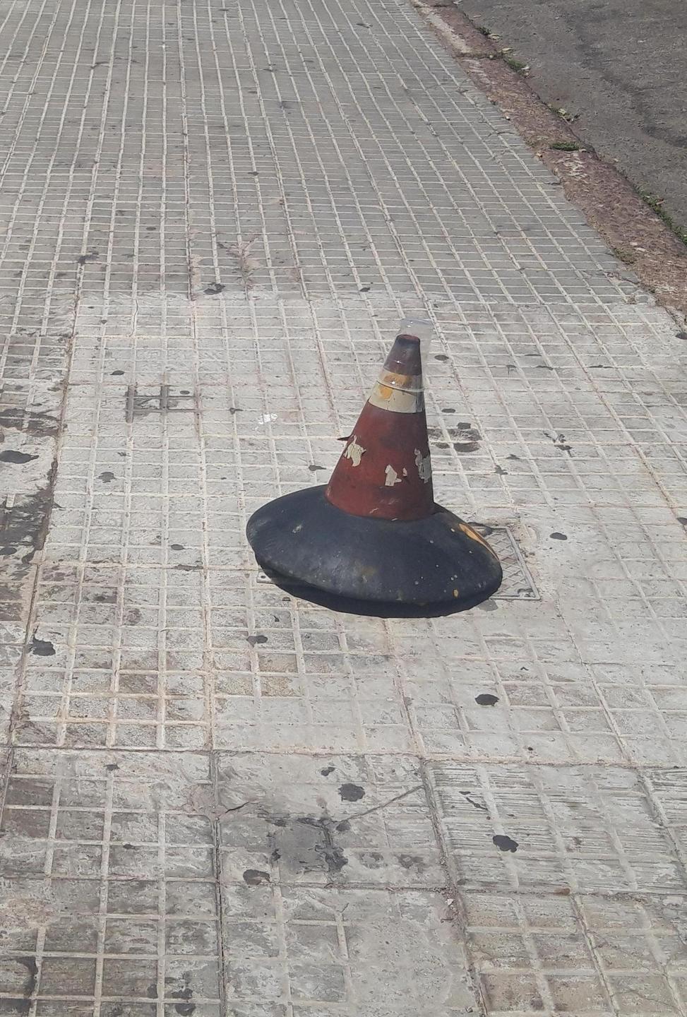 Marciapiede fuori uso, un cono come barriera