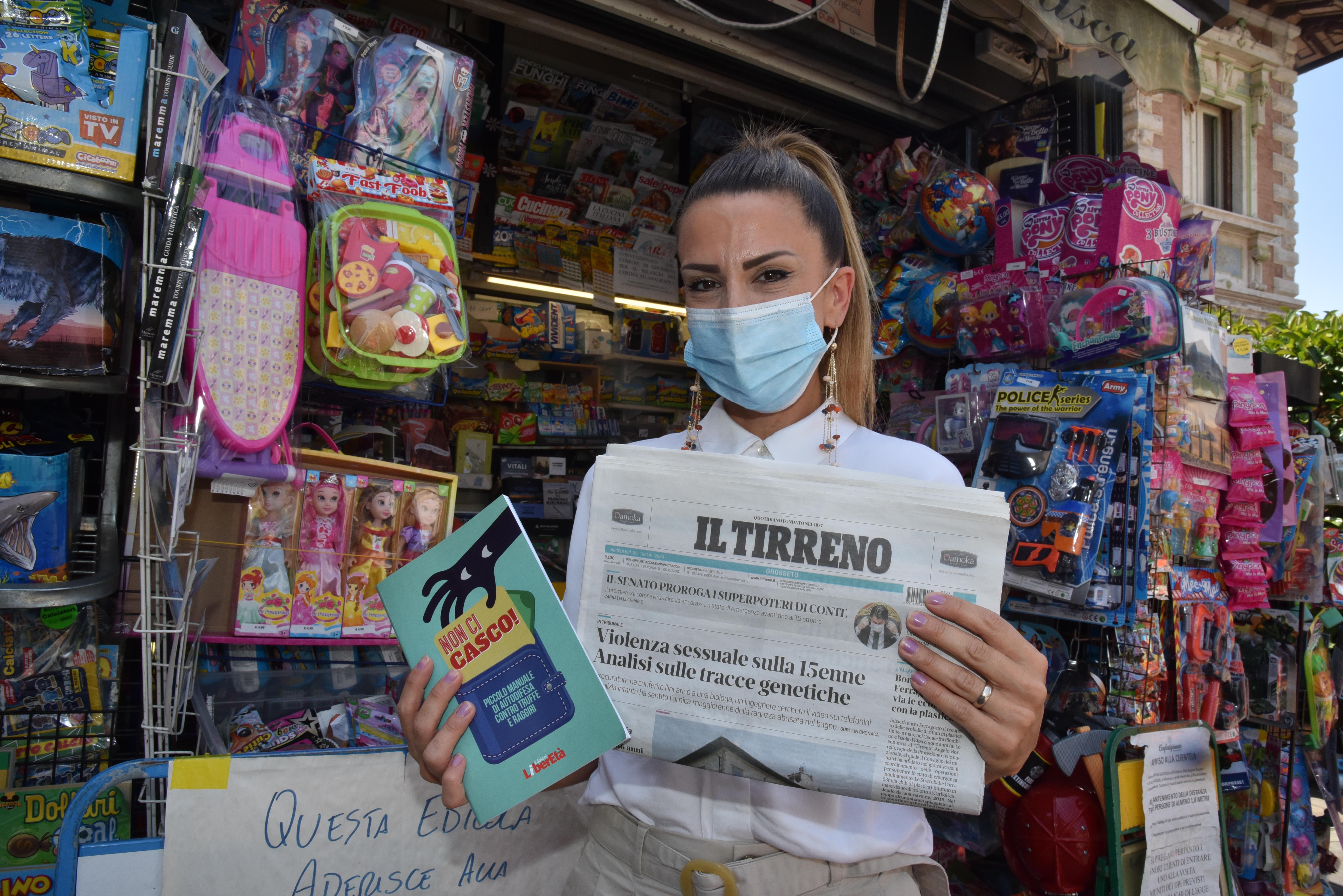 Una lettrice del Tirreno con la copia del giornale e il manuale "Non ci casco" appena ritirato in edicola (foto Agenzia Bf)