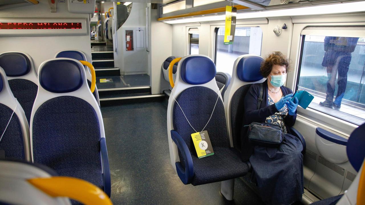 La carrozza di un treno regionale con i cartelli che segnalano il distanziamento