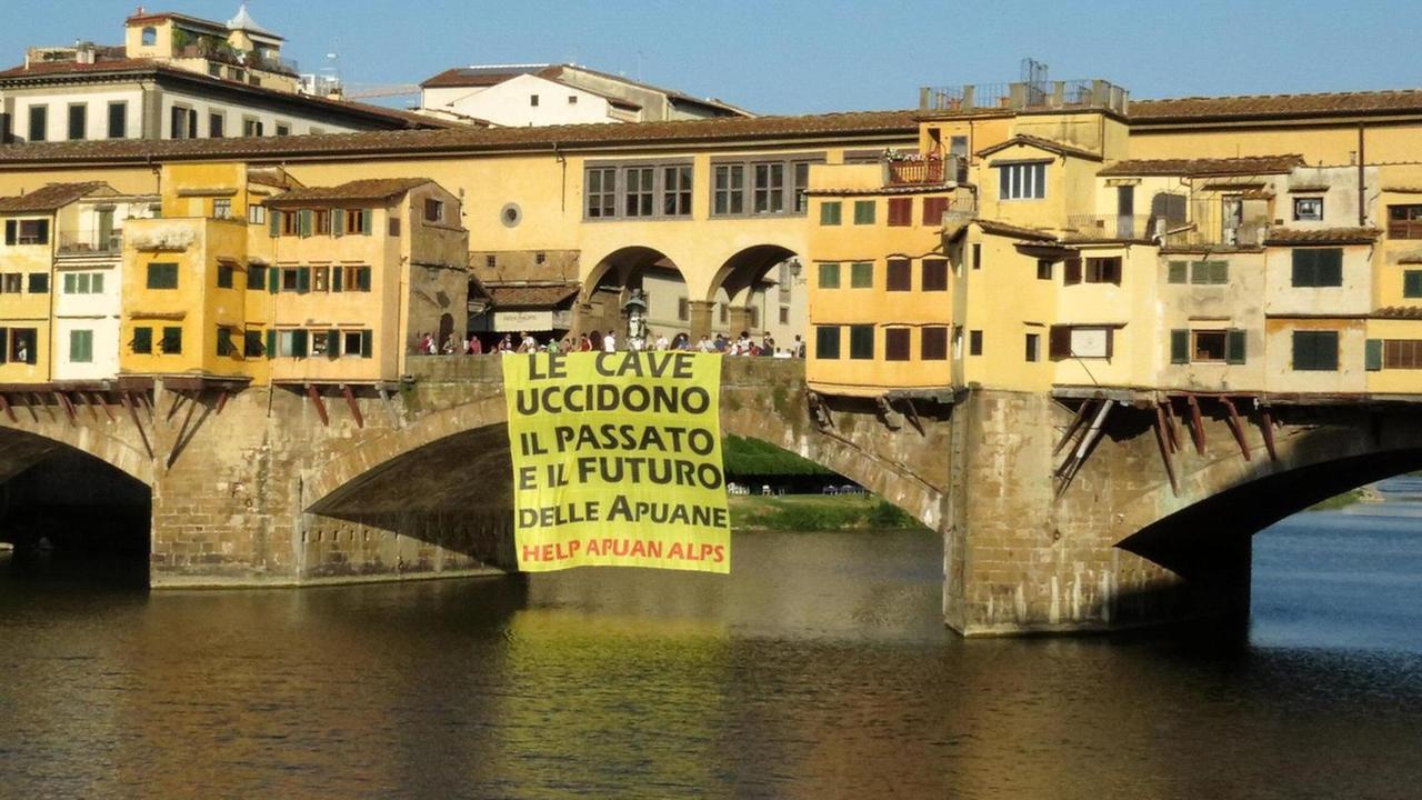 Uno striscione di protesta su Ponte Vecchio: «Le cave uccidono il futuro delle Apuane»