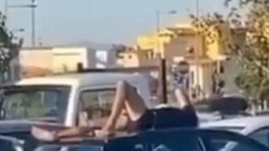Si sdraia sull’auto a prendere il sole al Parco Levante - VIDEO