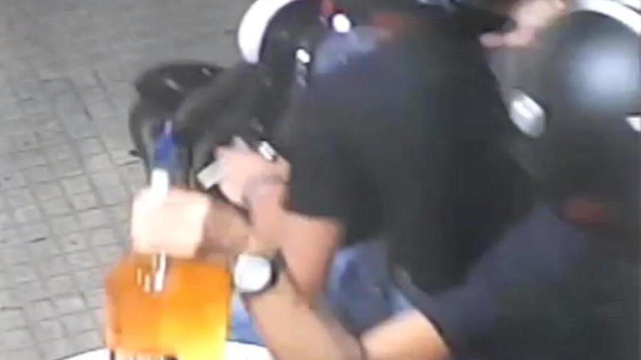 In scooter rubano bottiglia gigante dal tavolo del bar