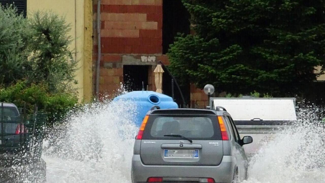 Un'auto si fa strada in un fiume d'acqua piovana