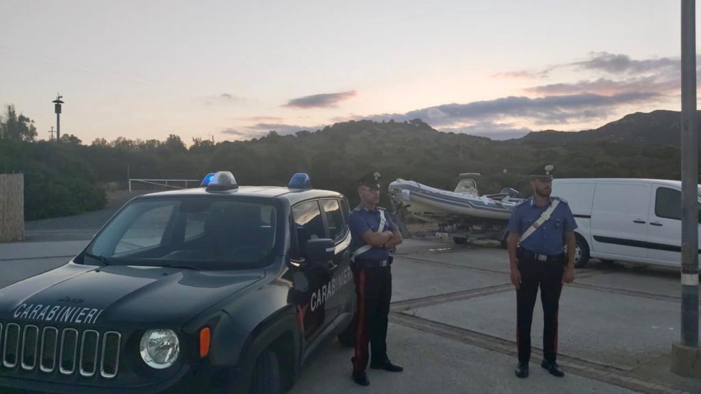 I carabinieri e, alle loro spalle, il gommone posto sotto sequestro