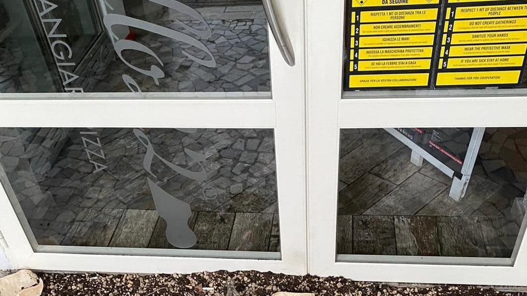 Vasi rotti e pavimento imbrattato davanti alla porta d'ingresso della pizzeria di piazza Garibaldi
