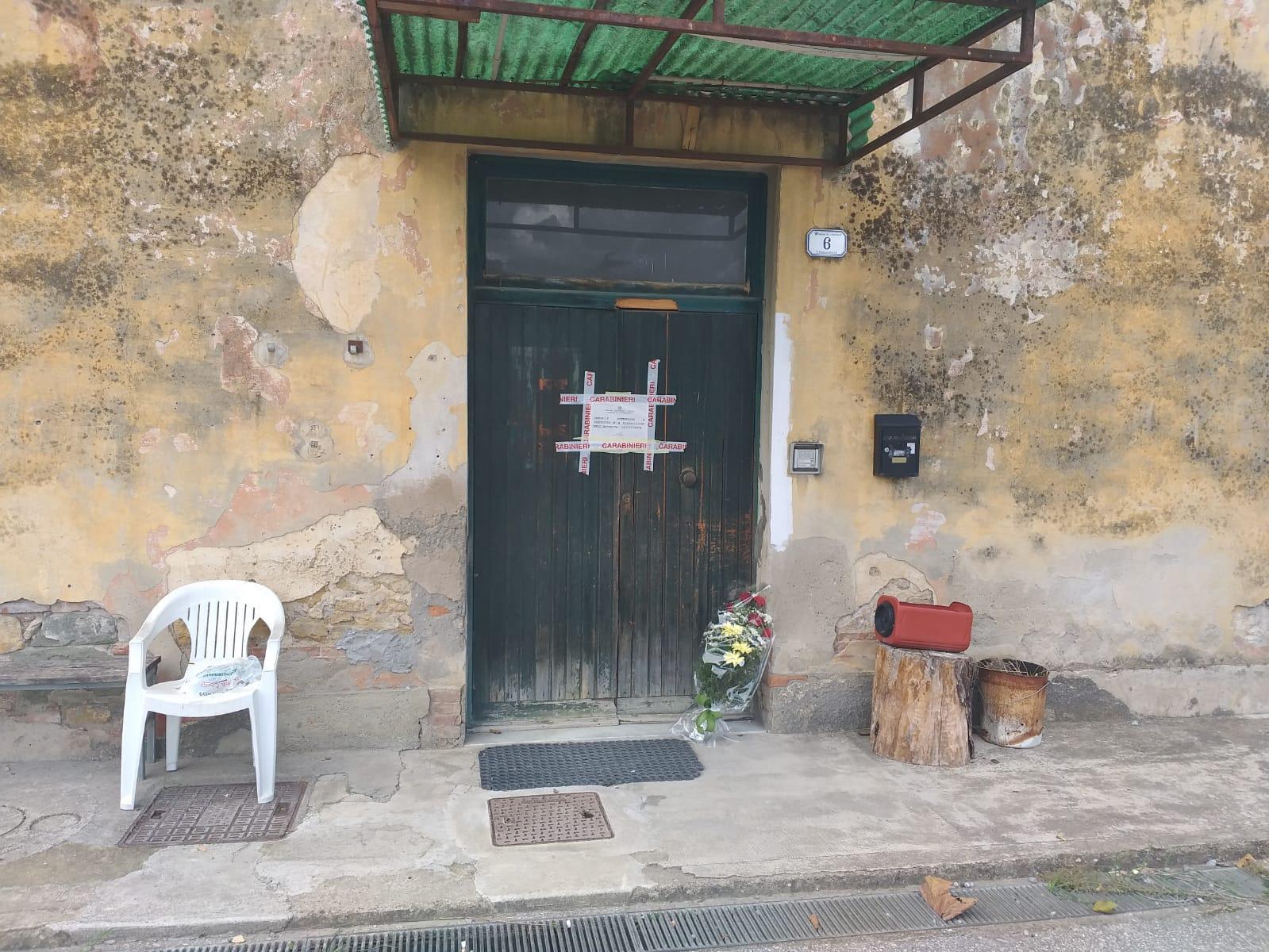 L'ingresso dell'ex stazione con i sigilli e un mazzo di fiori in ricordo del 56enne