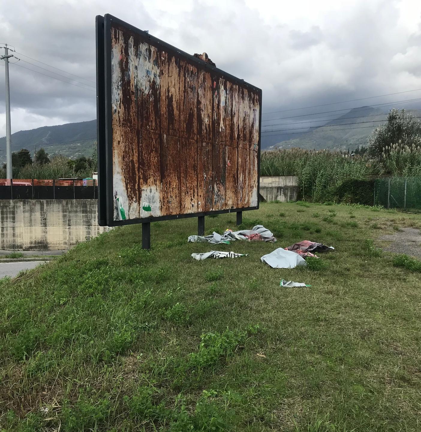Un cartellone arruginito in una cornice di degrado