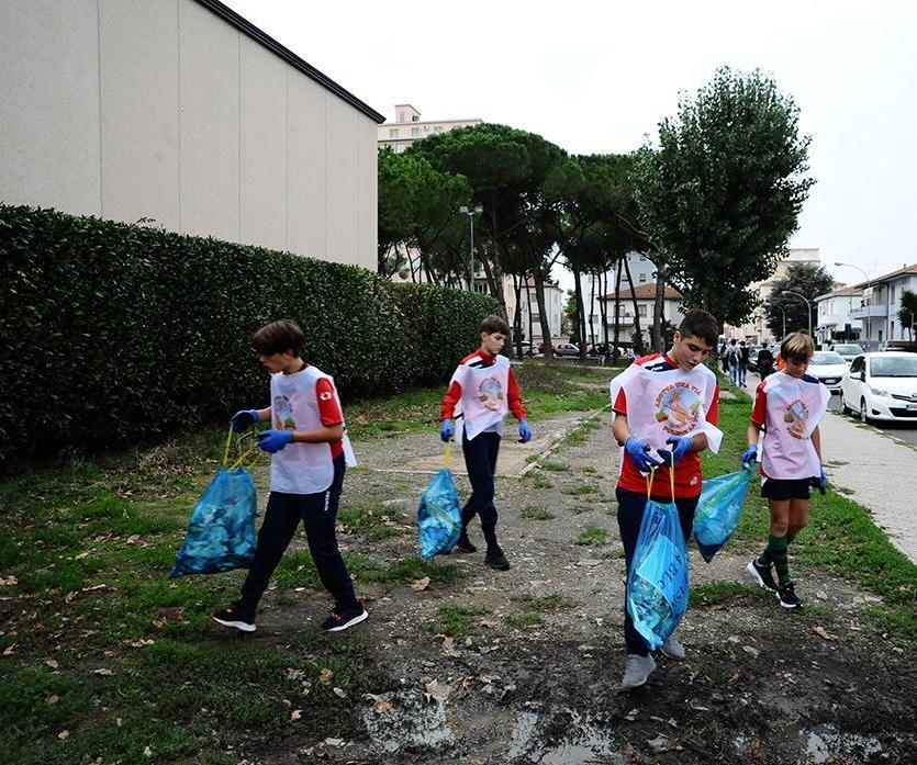 I ragazzi del rugby rossoblù al lavoro intorno al Villaggio scolastico (foto Michele Falorni/silvi)