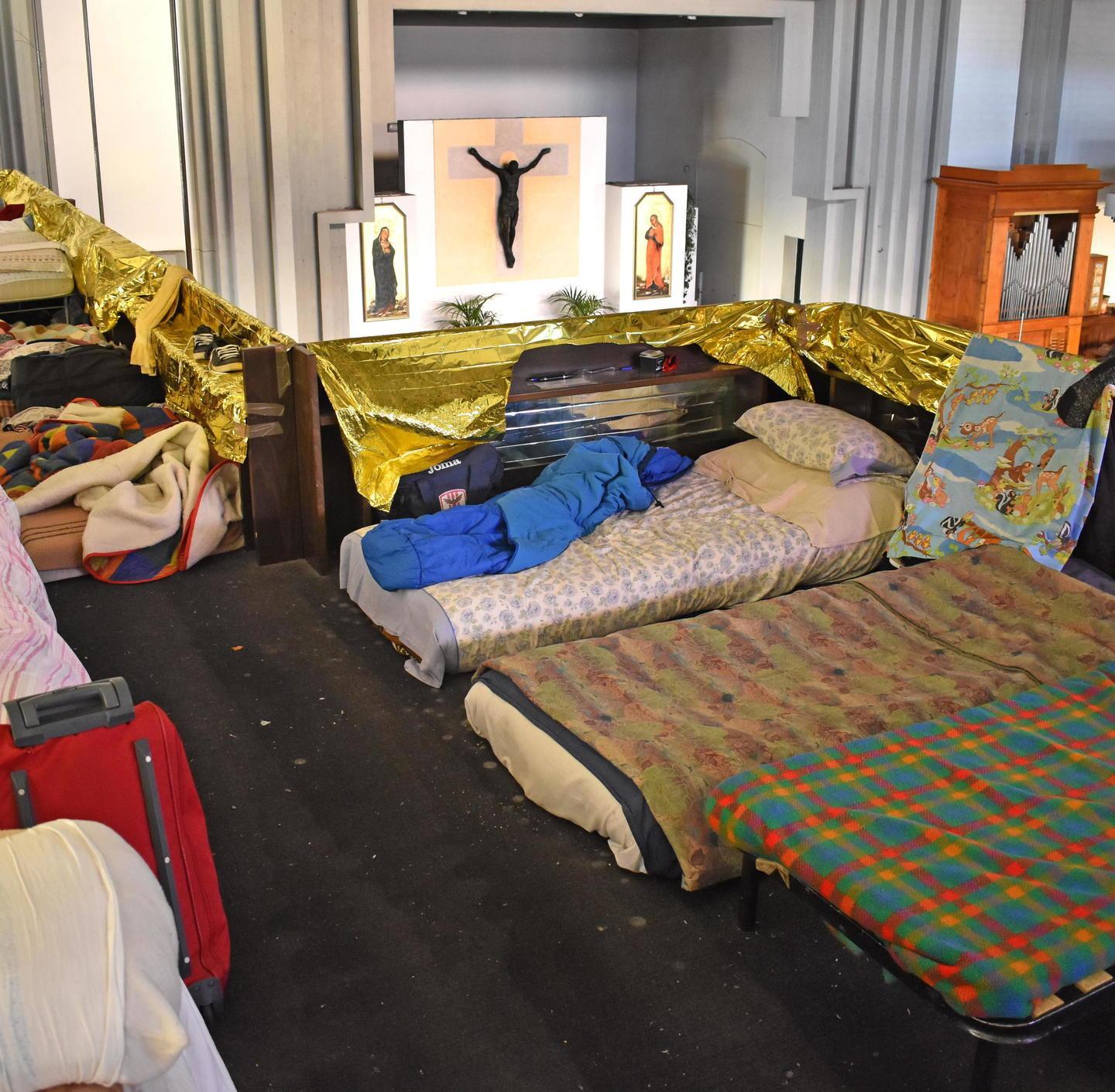 I giacigli di alcuni migranti nel matroneo della chiesa parrocchiale di Vicofaro