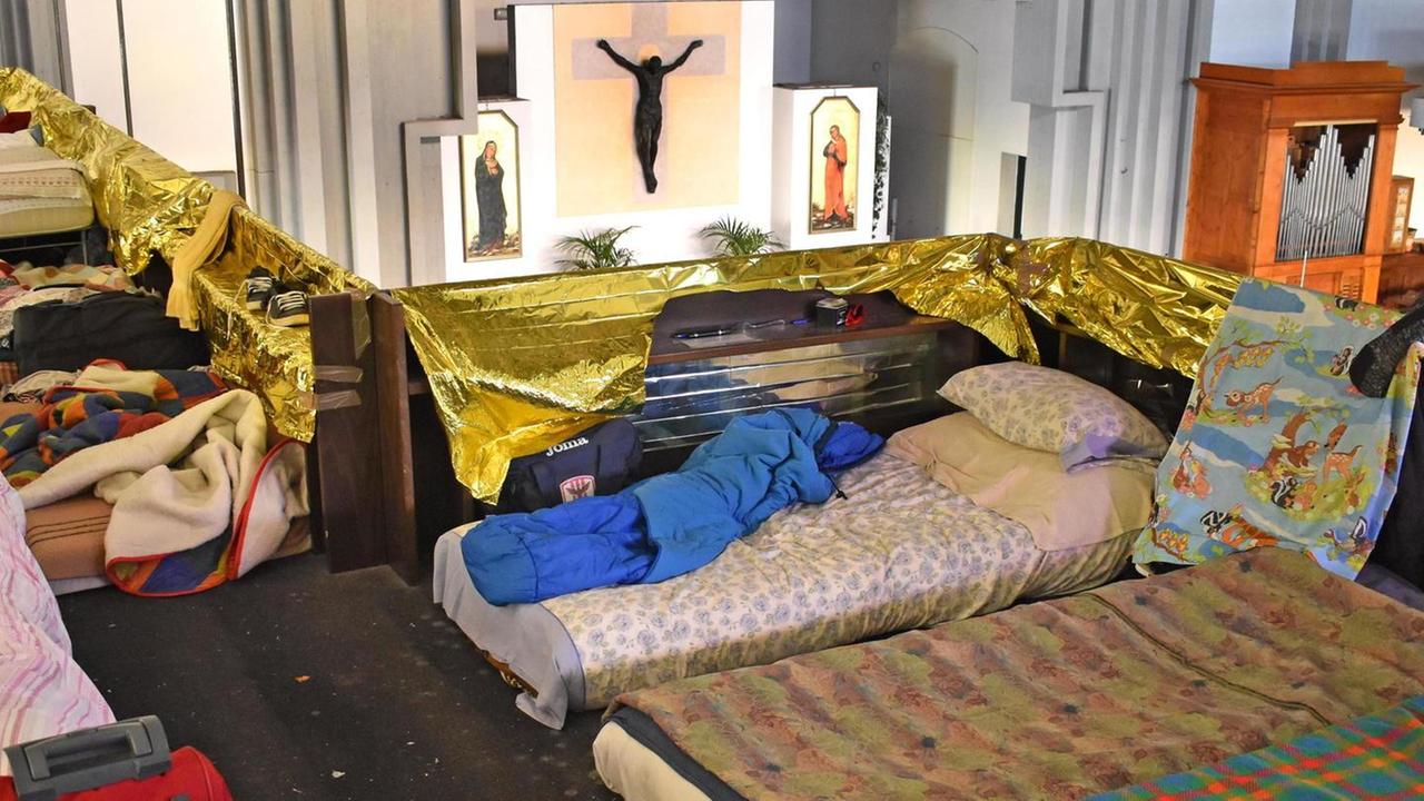 I giacigli di alcuni migranti nel matroneo della chiesa parrocchiale di Vicofaro