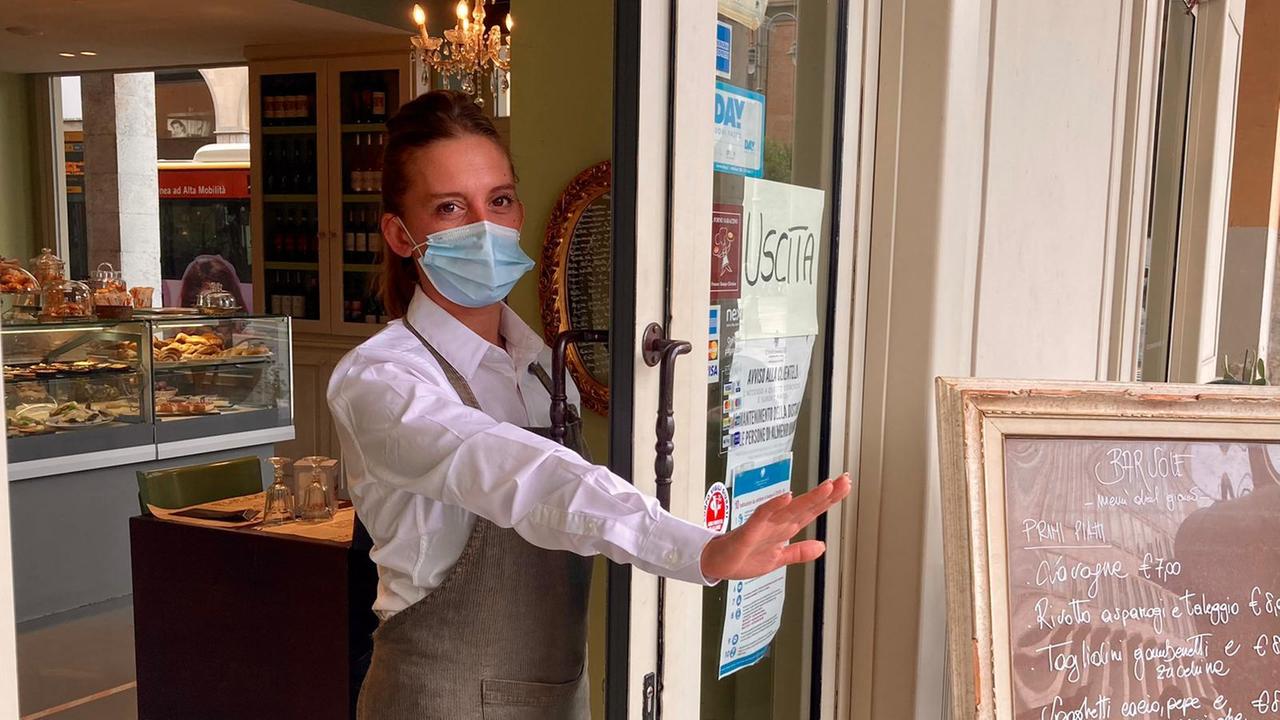 La porta "chiusa" del bar Sole con una dipendente che mostra come la vetrata non vi sia più (foto Dario Marzi)