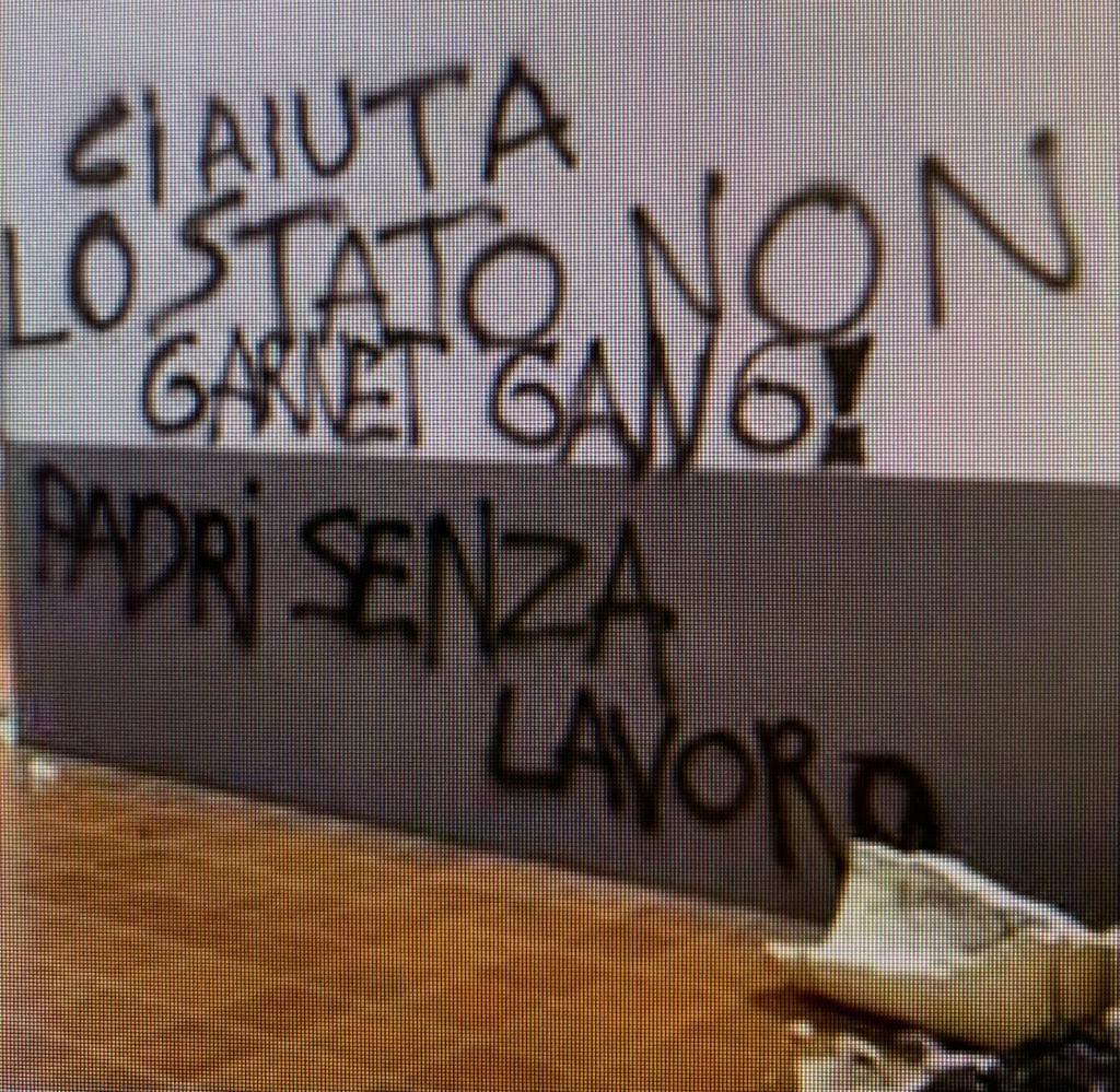 Una fioriera rotta e una delle scritte apparse su un muro del centro commerciale Panorama di Pontedera (Foto da Facebook)