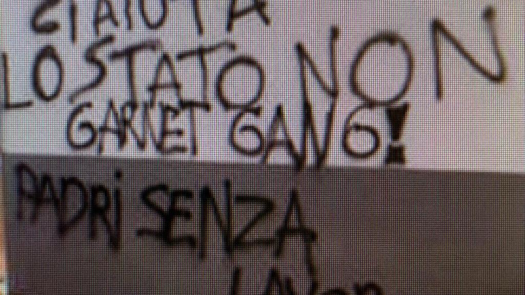 Una fioriera rotta e una delle scritte apparse su un muro del centro commerciale Panorama di Pontedera (Foto da Facebook)